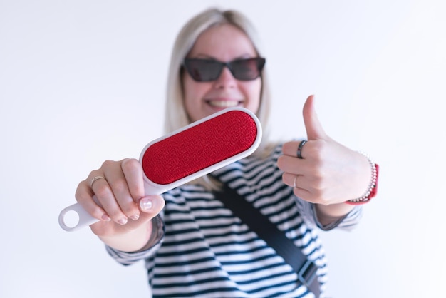 A happy woman holds a red electrostatic clothing brush and\
shows thumbs up on a white background cat cover difficult stained\
fabric tool cleanser dirt remove handle lint fluff tidy trash