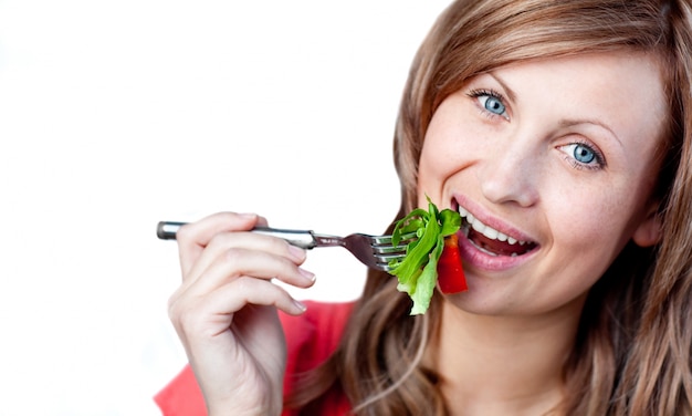 写真 幸せな女性はサラダを食べている