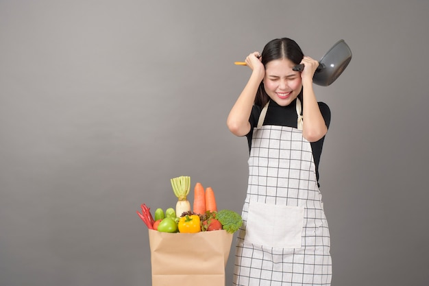 幸せな女は料理に健康食品を準備しています