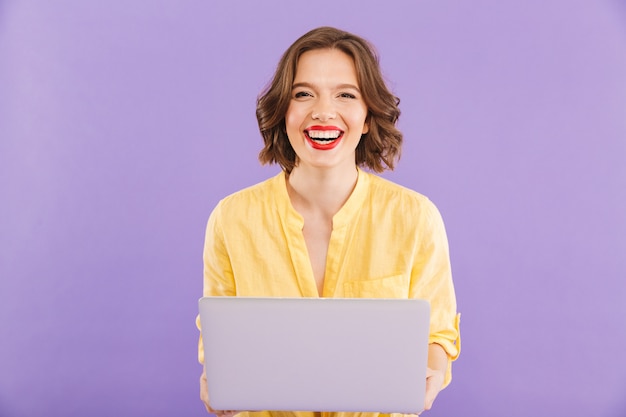Happy woman isolated over using laptop computer
