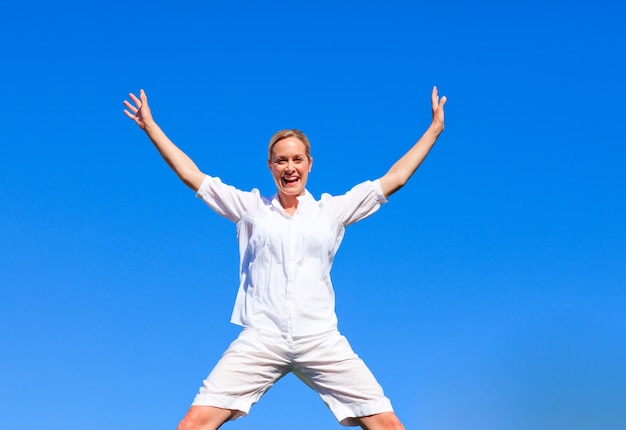 Happy woman jumping against blue sky