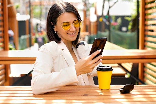 幸せな女性は彼女の携帯電話を見ながら笑う