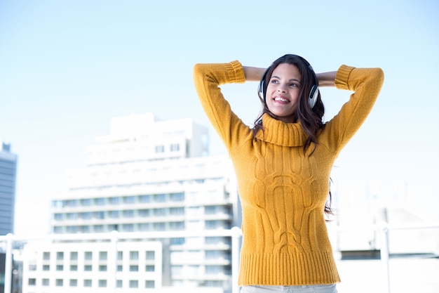 Happy woman listening music through headphones 