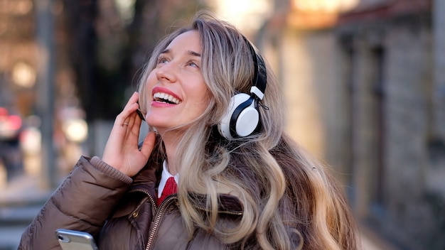 Happy woman listening to music on wireless headphones