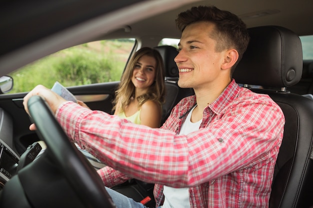 写真 車を運転している男を見ている幸せな女性