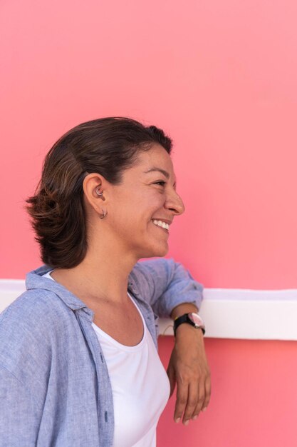 Happy woman looking away and smiling outdoors in the city