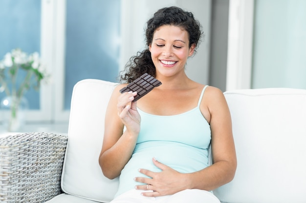 Happy woman looking at chocolate bar