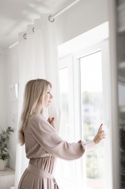 Photo happy woman looking out the window