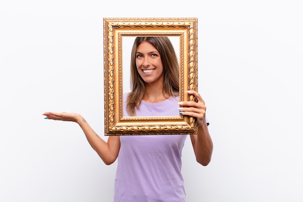 Happy woman looking through a classic golden frame