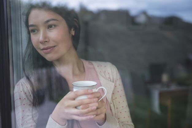 Happy woman looking through window