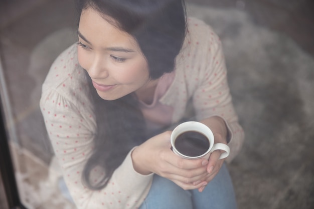 Happy woman looking through window