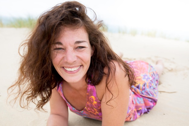 Happy woman lying at the beach on a sunny day