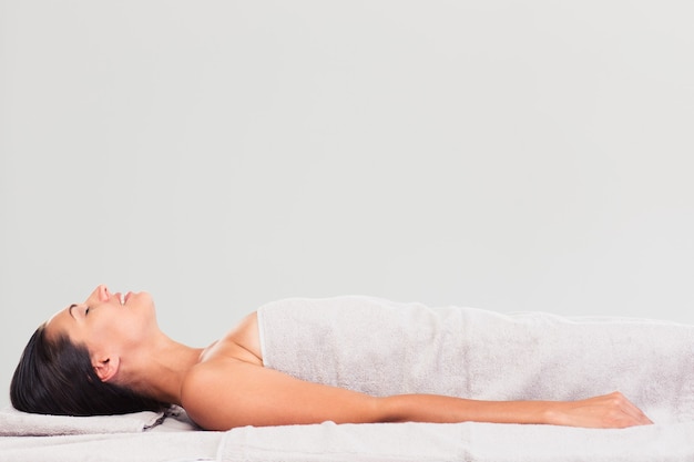 Happy woman lying on massage lounger