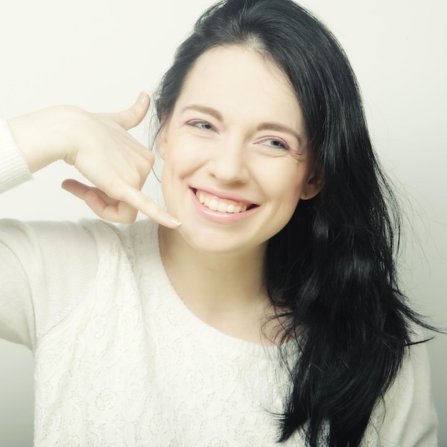 Happy woman making a call me gesture