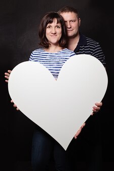 Felice donna e uomo con cuore bianco banner su sfondo lavagna