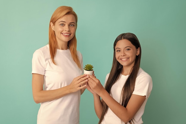 幸せな女の母と娘の子笑顔保持ポット植物青い背景母