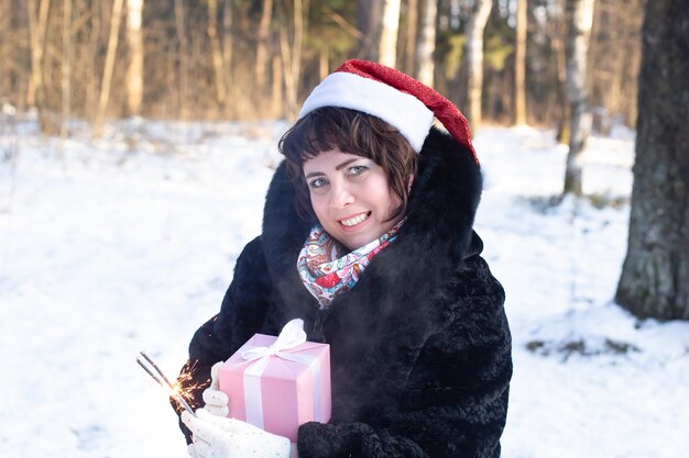 The happy woman in nature in winter with sparklers