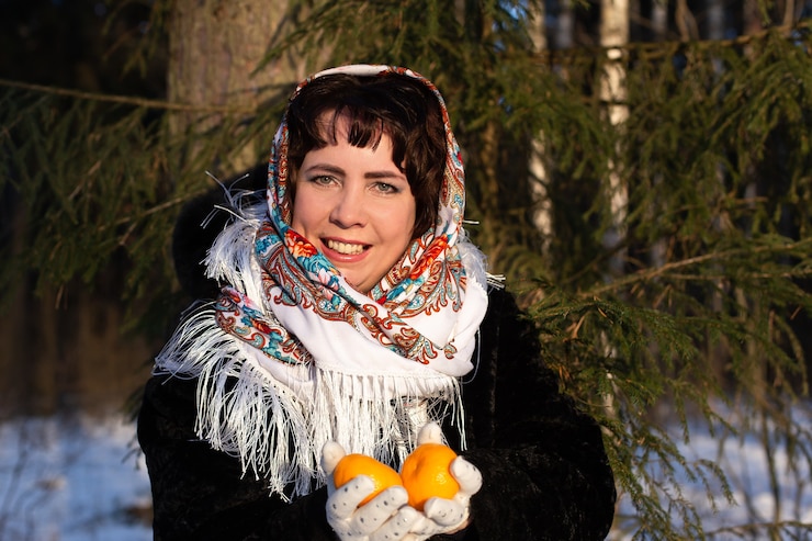 Фотография счастливая женщина на природе зимой с мандаринами