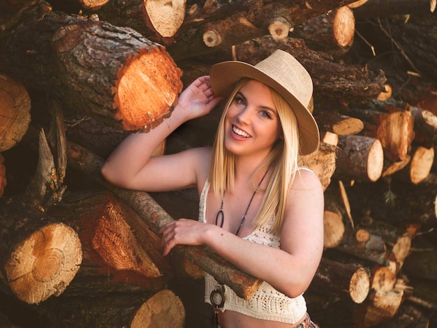 Happy woman near logs in countryside