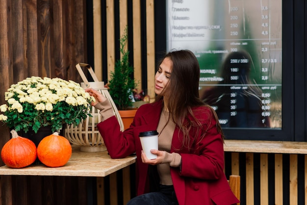 Donna felice al caffè all'aperto che beve e sorride