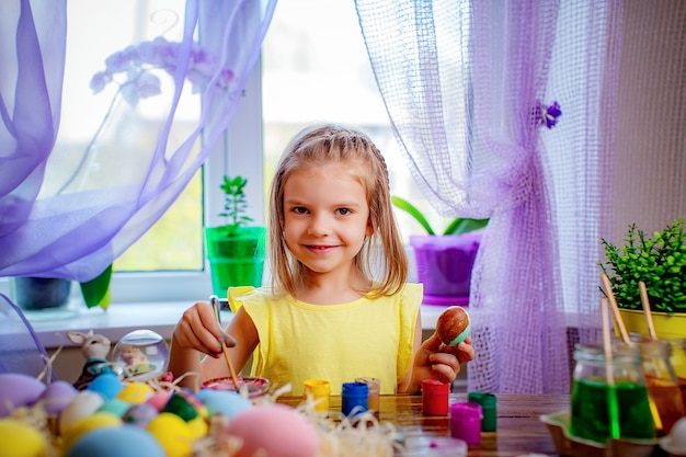 Happy woman painting easter eggs, small child at home have fun. spring holiday