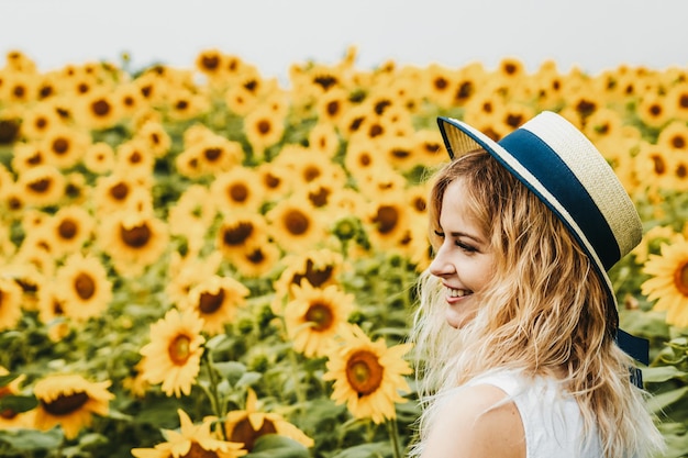 Happy woman photographed on the background of sunflower field.
