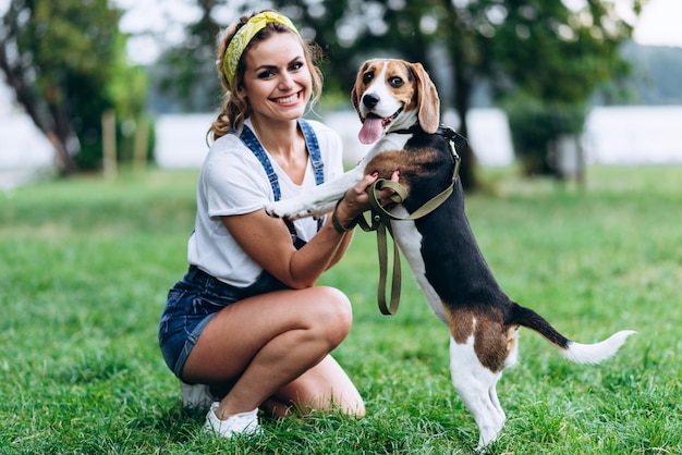 犬と遊んで、カメラを見て幸せな女。 -画像