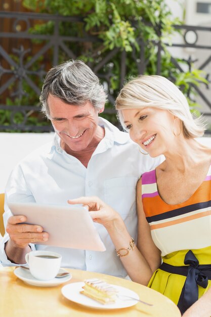 Happy woman pointing at tablet to man