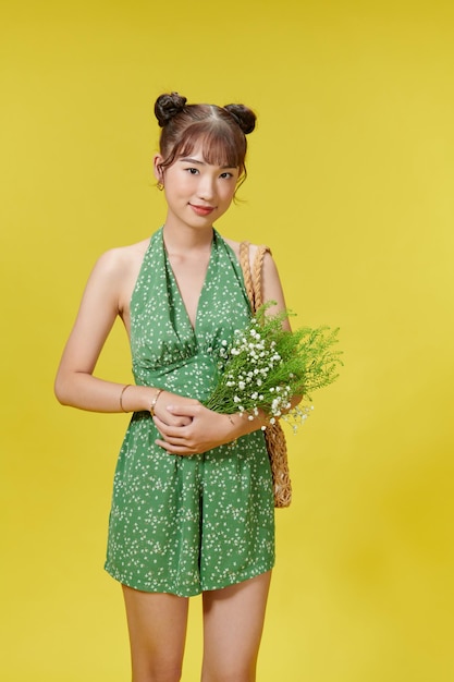 Happy woman in polka dot outfit laughing and holding flowers