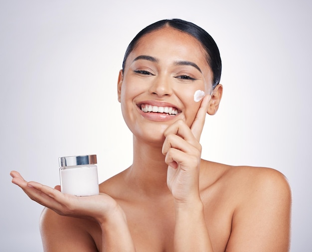 Happy woman portrait and cream product in skincare moisturizer or cosmetics against a white studio background Female person or model smiling for cosmetic lotion or facial treatment on mockup space