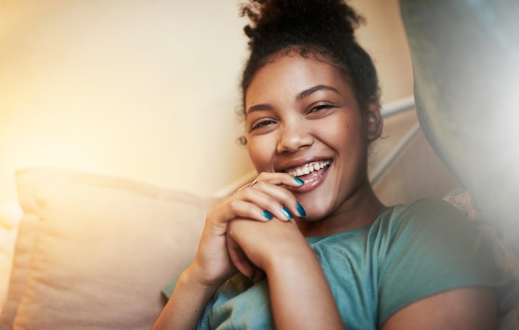 Photo happy woman portrait and relax with bed for fun night laugh or comedy with humor at home young female person and smile with light in bedroom for comfort relaxed weekend or holiday alone at house