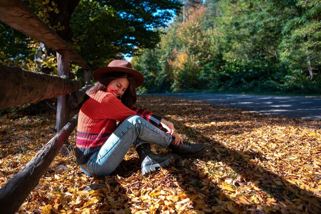 Happy woman posing near fence autumn sunny day