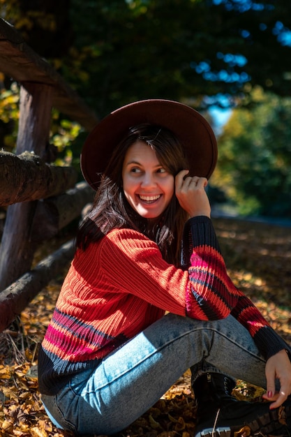 Happy woman posing near fence autumn sunny day