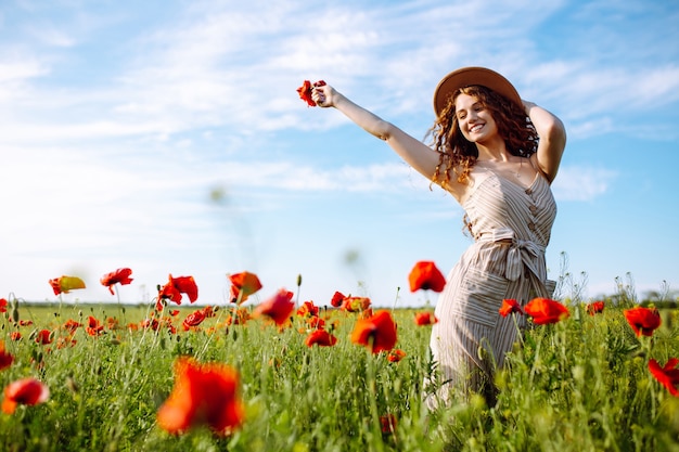 Happy woman posing in a poppy field 