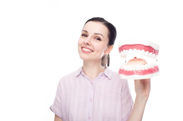 happy woman in a purple shirt holds a huge jaw mockup in her hand white background