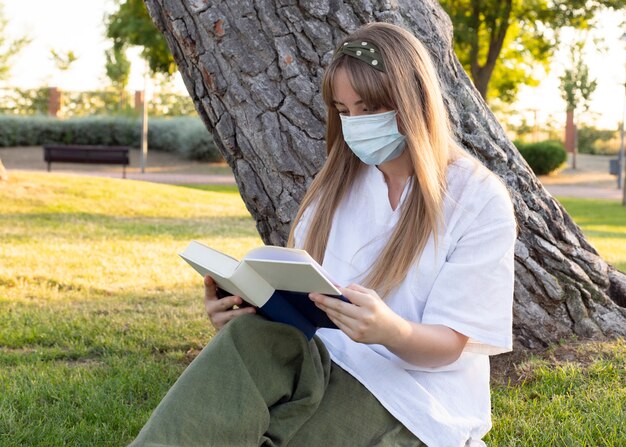 Happy woman reading a book in the park