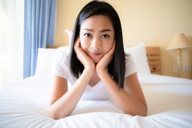 Happy woman relax on the bed with morning light.