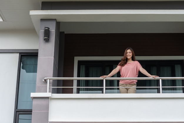 Photo happy woman relaxing and looking from balcony of her home