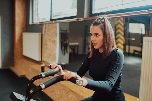 ジムで自転車運動に乗って幸せな女性