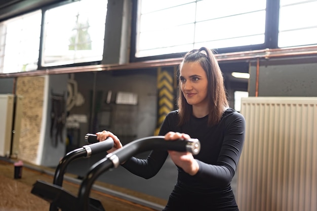 ジムで自転車運動に乗って幸せな女性