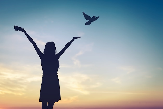 Photo happy woman rise hand and birds on sky background