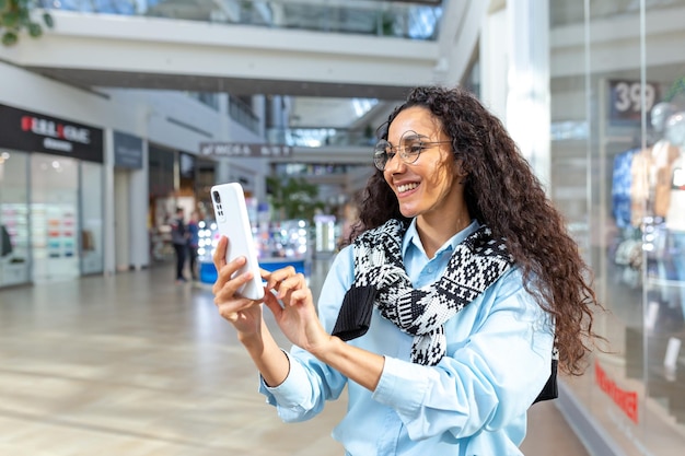 Happy woman shopping for clothes during the period of discounts\
and promotional offers hispanic