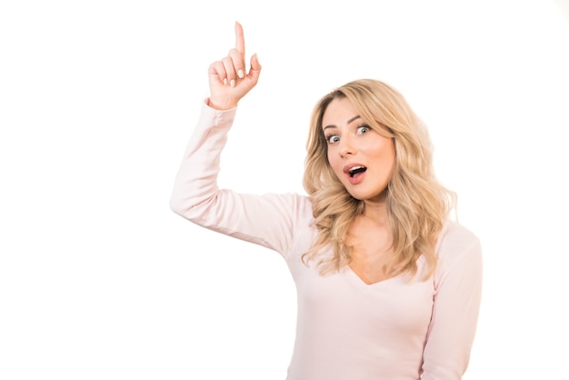 The happy woman showing forefinger on the white background