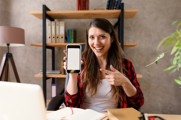 Happy woman shows something in her modern smartphone