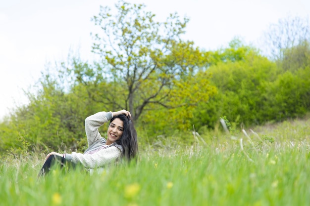 Foto donna felice che si siede nel paesaggio