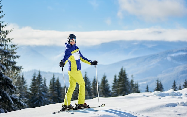 Счастливая женщина-лыжник позирует на лыжах