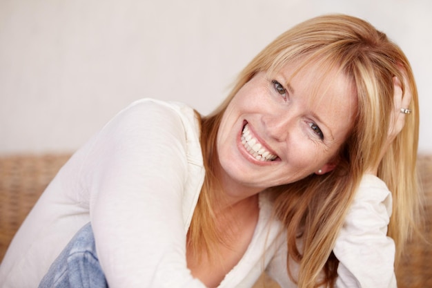 Photo happy woman and smile with portrait on face joyful and alone in home natural beauty or headshot female beautiful or thinking with idea mature person and cheerful lady in house or blonde hair