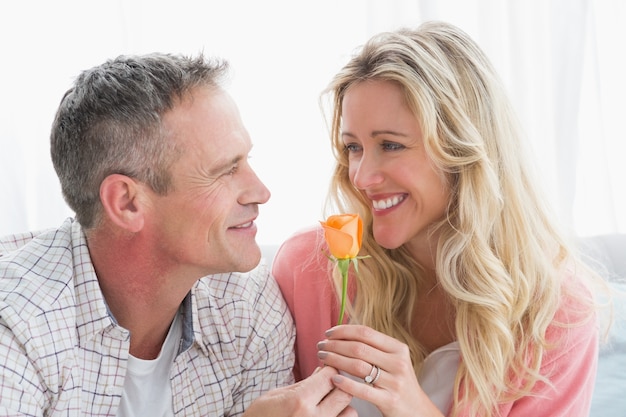 Happy woman smiling at partner who has given her a rose