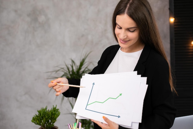 Happy woman smiling showing growth diagram satisfied with financial and economic growth of his busi