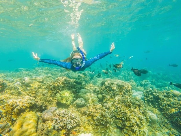 シュノーケリングマスクの幸せな女性サンゴ礁の海のプールで熱帯の魚と一緒に水中に潜る旅行ライフスタイルウォータースポーツアウトドアアドベンチャー夏のビーチホリデーの水泳レッスン